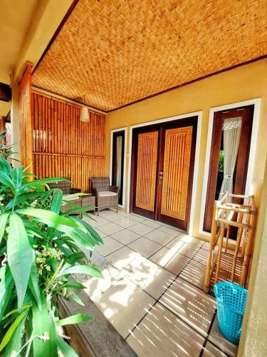 a screened in porch of a house with a patio at Petit Boo Amed in Amed