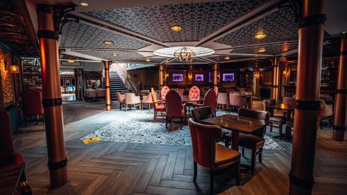 a bar with tables and chairs in a restaurant at Beechlawn Hotel in Belfast