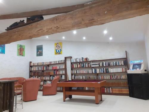una biblioteca con estanterías de madera llenas de libros en studio atypique et reposant, en Verdelot