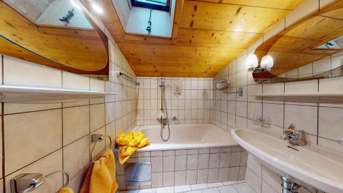 a bathroom with a tub and a sink at Apart Alpenstern in Nauders