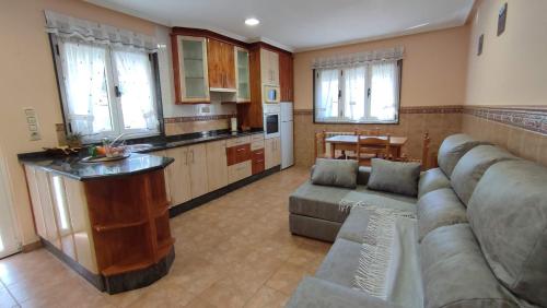 sala de estar amplia con sofá y cocina en Apartamentos Casa Alvarina - Luarca, en Cortina