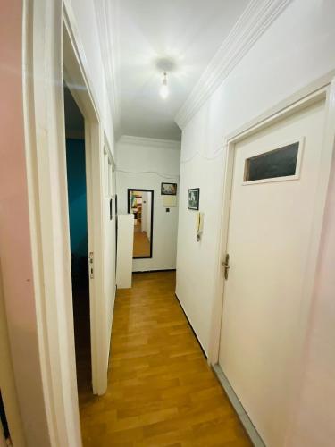 un pasillo vacío con paredes blancas y suelo de madera en Private Room whit everything you need, en Tánger