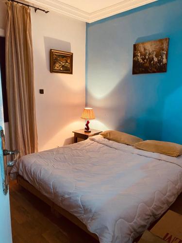 1 dormitorio con 1 cama con pared azul en Private Room whit everything you need, en Tánger