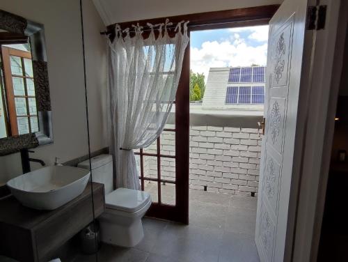 ein Bad mit einem Waschbecken, einem WC und einem Fenster in der Unterkunft The Fairway Guesthouse Senekal in Senekal