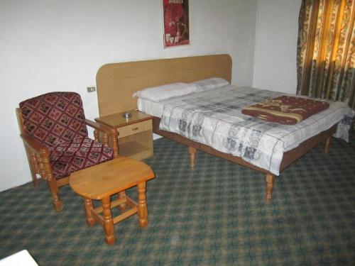 a small bedroom with a bed and a chair at Asia Hotel in Amman