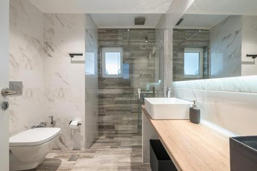 y baño con lavabo, aseo y bañera. en Petralona Stylish Penthouse, en Atenas