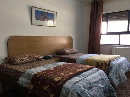 a room with two beds and a window at Asia Hotel in Amman