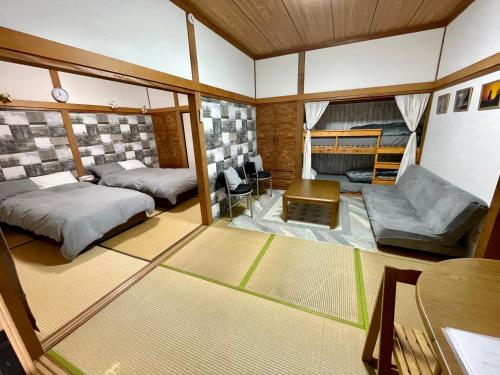 Muroto的住宿－Sakurahome&El Flamenquito，一间小房间,配有两张床和一张沙发