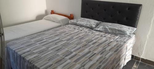 1 cama con cabecero negro en un dormitorio en Normi en La Rioja