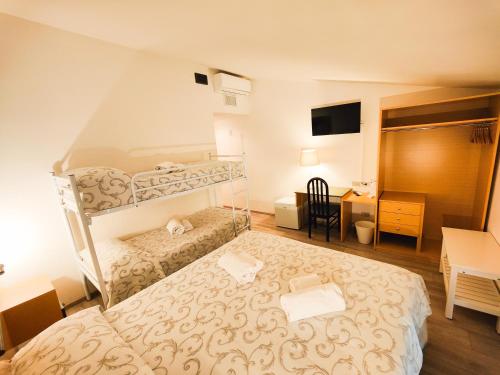 a bedroom with two bunk beds and a desk at Albergo B&B Tenesi in Manerba del Garda
