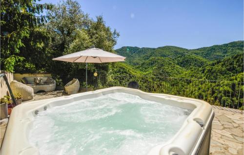 - un bain à remous avec un parasol et des montagnes en arrière-plan dans l'établissement Gorgeous Apartment In Carcheto Brustico, à Carcheto