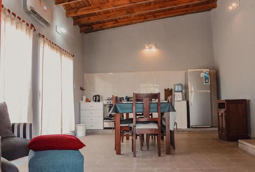 a kitchen with a table and chairs and a refrigerator at El Pedregal Cabaña rural 2 dorm Hasta 6 personas in Cafayate