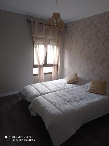 a bedroom with a large white bed with a window at Zapaterías in León