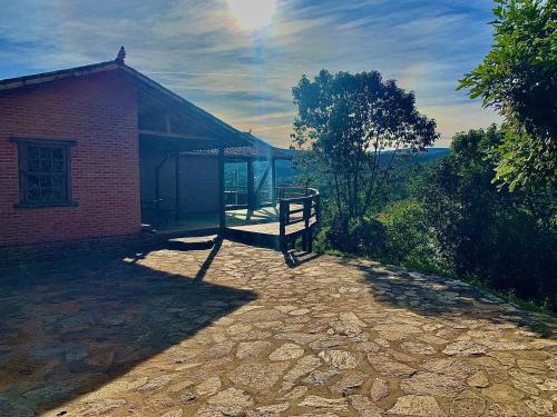 康塞桑依荻波卡的住宿－Pedra que Estala / Reserva Alto da Colina，石头庭院上带屋顶的小砖砌建筑