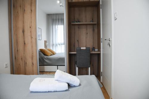 um quarto com duas toalhas numa cama e um espelho em ANNA 2 Apartment free parking em Novi Sad