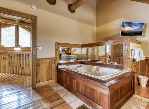 a large bathroom with a large tub and wooden walls at Newly Renovated Perfect 2 Bedroom W Indoor Jacuzzies, Hot Tub, Pool, Sauna, Golf! in Pigeon Forge