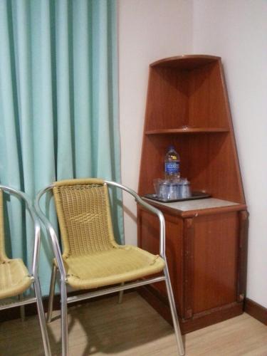 a room with two chairs and a table and a shelf at Istana Monaco Hotel in Tawau