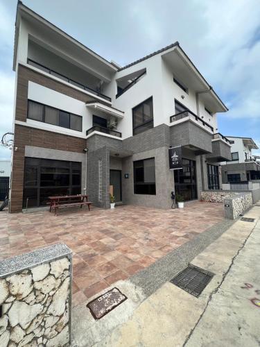 a large house with a patio in front of it at Traveler's Campfire B&B in Magong