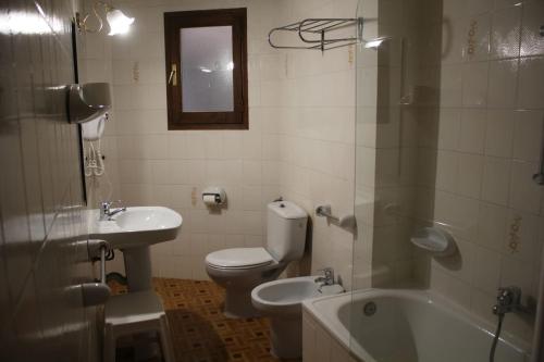 a bathroom with a toilet and a sink and a tub at Apartamentos Pessets Adelaida in Sort