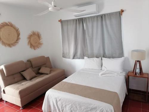 1 dormitorio con 1 cama y 1 sofá en Creta Hotel & Suites, en Mazatlán