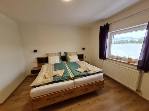 una camera da letto con un grande letto con una grande finestra di Ferienwohnung Waldfrieden a Scheidegg
