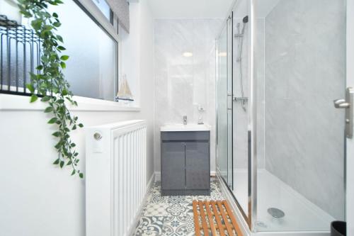 een badkamer met een douche en een wastafel bij Lowther House by YourStays in Stoke on Trent