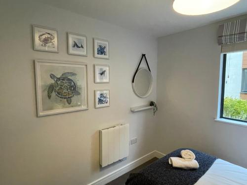 1 dormitorio con cama y espejo en la pared en 4 Putsborough - Luxury Apartment at Byron Woolacombe, only 4 minute walk to Woolacombe Beach!, en Woolacombe