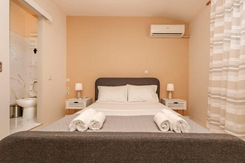 a bedroom with a large bed with towels on it at Sunset Beach House in Agios Georgios