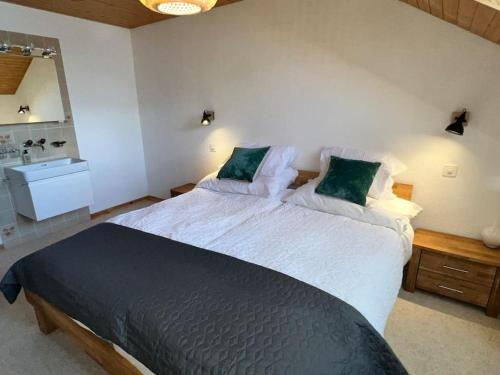 a bedroom with a large bed with green pillows at Apartment in Wengen - Amazing views, centrally located by train station in Wengen