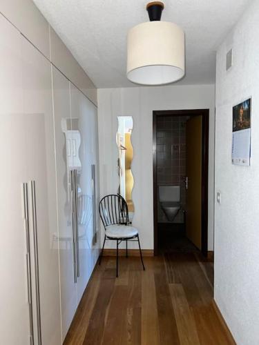 a hallway with a chair in a room with a refrigerator at Apartment in Wengen - Amazing views, centrally located by train station in Wengen