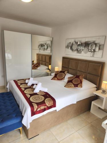 1 Schlafzimmer mit 2 Betten und einer blauen Bank in der Unterkunft Apartments - Villa Sabrina in Brela