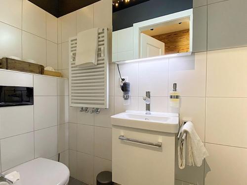 a white bathroom with a sink and a toilet at Alpenstil, 4 Pax, zentral, 1 Parkplatz - RE31 in St. Moritz
