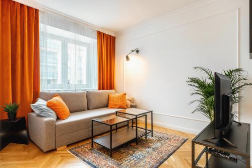 ein Wohnzimmer mit einem Sofa und einem TV in der Unterkunft Apartament Nowolipki z sypialnią in Warschau