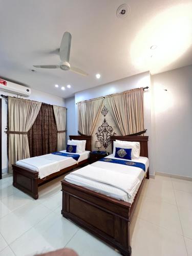 卡拉奇Sea View Inn Guest House的有两张床和天花板的卧室