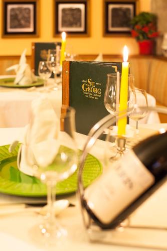 a table with wine glasses and a book on it at Hotel St. Georg in Zell am See