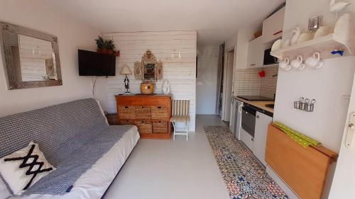 a living room with a couch and a kitchen at MALDIVES Joli T2 cabine proche plage Richelieu Cap d'Agde in Cap d'Agde