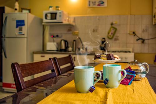 una mesa con dos tazas de café y un plato de comida en Dto Ha Naca Ushuaia en Ushuaia