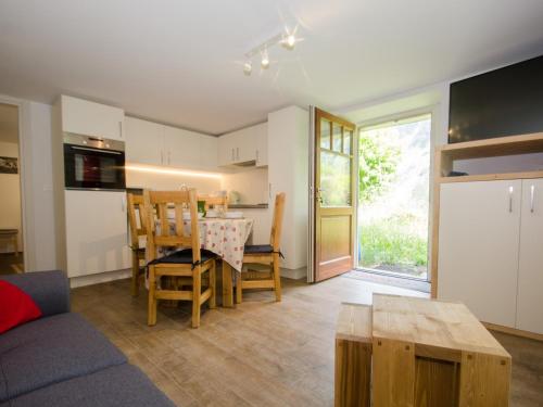 une cuisine et un salon avec une table et des chaises dans l'établissement Charmant T3 rénové avec jardin, parking & wifi à Chamonix - FR-1-343-206, à Chamonix-Mont-Blanc
