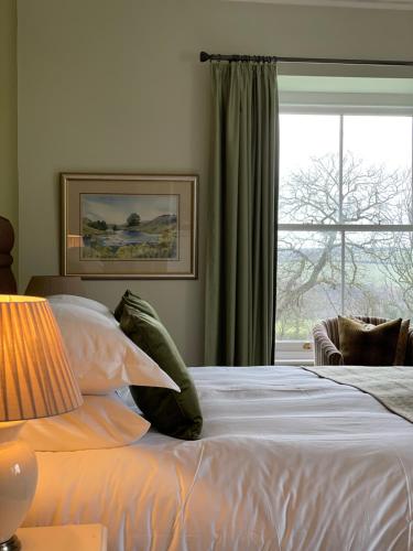 a bedroom with a white bed with a window at Caemorgan Mansion in Cardigan