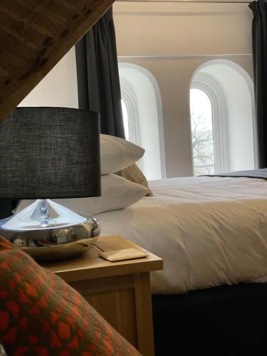 a bedroom with two beds and a table with a lamp at Caemorgan Mansion in Cardigan