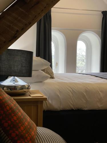 a bedroom with a bed and two windows at Caemorgan Mansion in Cardigan