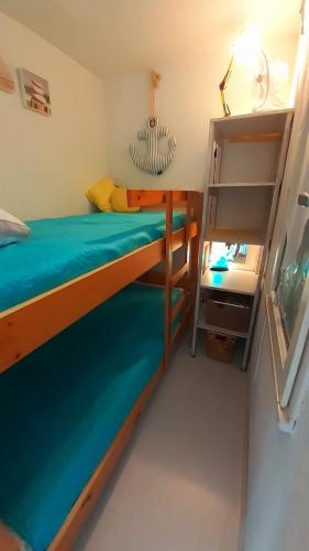 - une chambre avec 2 lits superposés et une étagère dans l'établissement MALDIVES Joli T2 cabine proche plage Richelieu Cap d'Agde, au Cap d'Agde