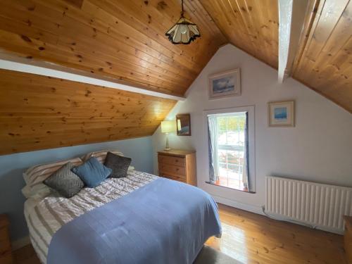 サーリスにあるMaggie's Cottageの木製の天井が特徴のベッドルーム1室(ベッド1台付)