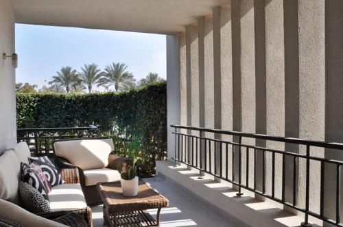 a balcony with two chairs and a table at Axxodia Cairo Festival Residence in Cairo