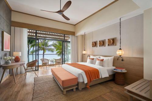 1 dormitorio con cama, escritorio y ventana en Boma Resort Nha Trang, en Nha Trang
