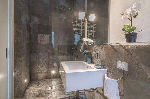 een badkamer met een witte wastafel en een douche bij enJoy Home - Mansarda nel cuore di Padova in Padua