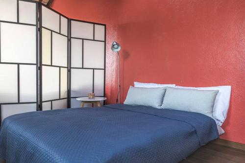 een slaapkamer met een blauw bed en een rode muur bij enJoy Home - Mansarda nel cuore di Padova in Padua