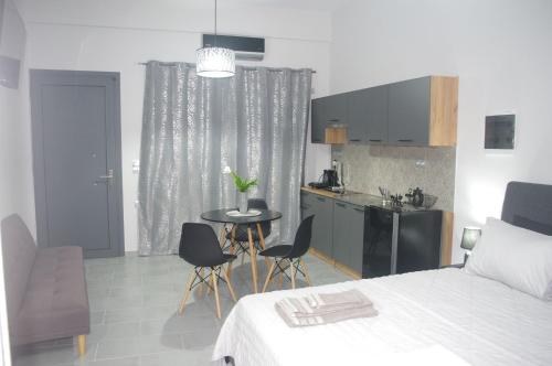 a bedroom with a bed and a table and a kitchen at Irene Luxury Apartments in Myrtos