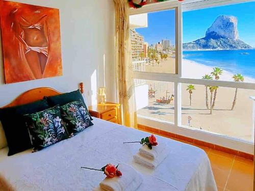 een slaapkamer met een bed en uitzicht op het strand bij Calpe - Súper Primera Línea de Playa - 3 Dormitorios in Calpe