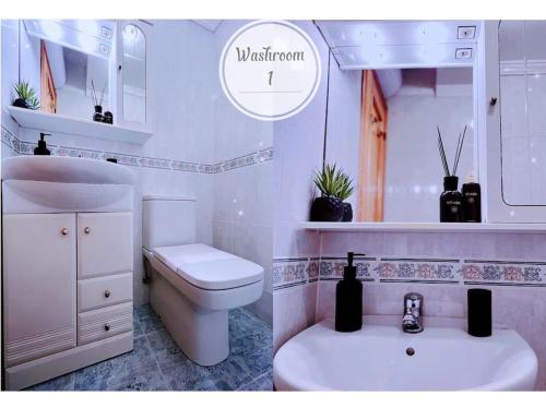 een witte badkamer met een toilet en een wastafel bij Calpe - Súper Primera Línea de Playa - 3 Dormitorios in Calpe